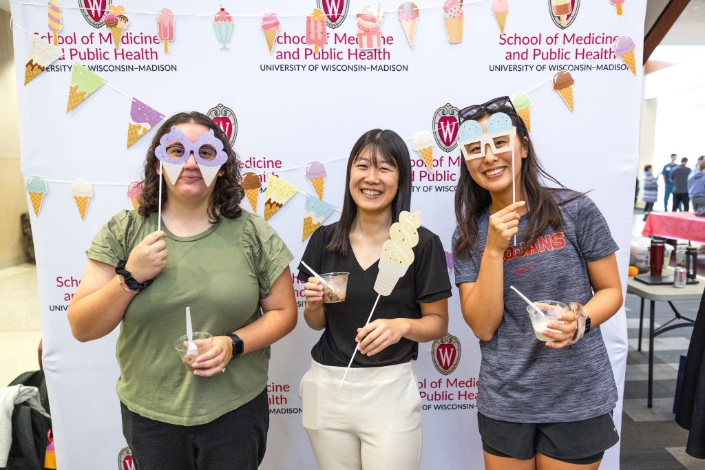People pose with fun props at the social.