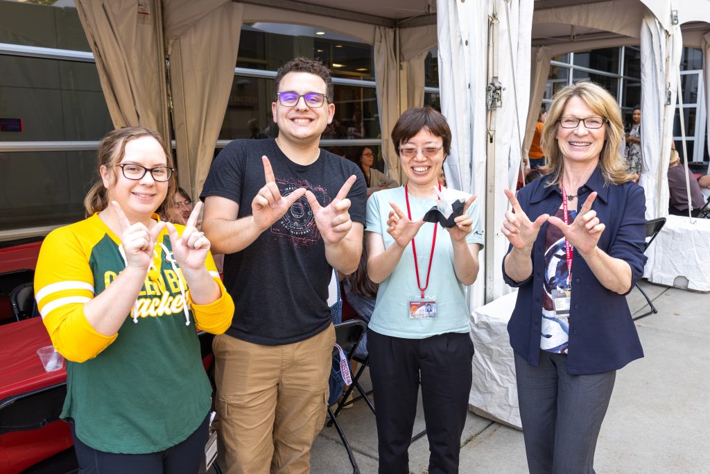School community members give the W sign outside at the Ice Cream Social.