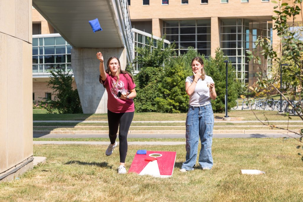 Two students play bean bag toss