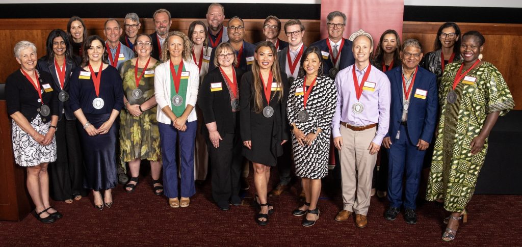 A group of smiling individuals with medals around their necks