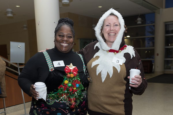 SMPH faculty pose in festive attire for the 2025 Sweater Weather Social.