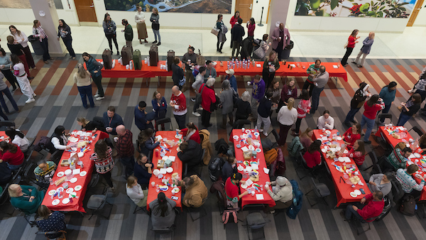 SMPH community sit at tables decorating cookies at the 2025 SMPH Sweater Weather Social.