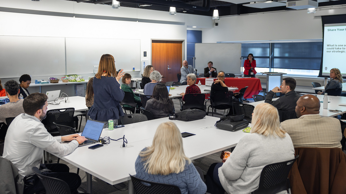 A group of people participate in a discussion in a classroom
