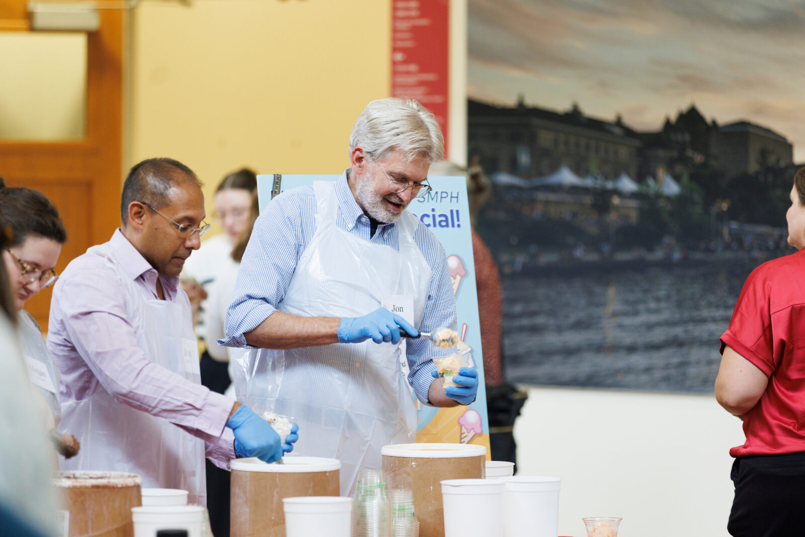 Vice Dean Audhya and Associate Dean for Public Health and Community Engagement Jonathan Temte serve Babcock ice cream.